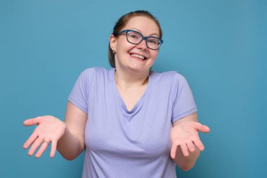 Gözlüklü, omuz silkmiş, ne yapacağı hakkında hiçbir fikri olmayan cahil, beyaz bir kadın..