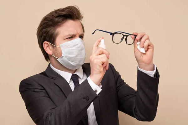 Hombre Caucásico Con Máscara Médica Usando Traje Desinfectando Las Gafas —  Fotos de Stock