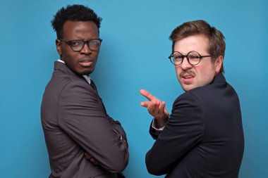 Şikayet eden iki adam, iş ortağıyla tartışıyor. Takım elbiseli hoşnutsuz ve rahatsız adamlar bir el sinirli ve şaşkın, şaşkın, şaşkın bakışlı, ne olduğunu anlamak