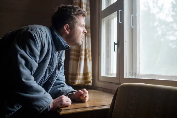 Dojrzały Rosyjski Dorosły Mężczyzna Wyglądający Przez Okno Podczas Kwarantanny Covid — Zdjęcie stockowe