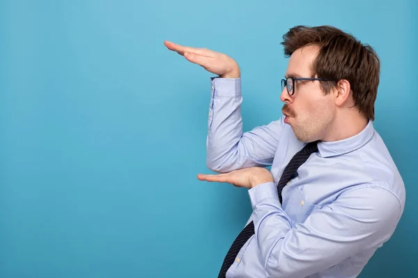 Funny angry handsome young man in blue shirt standing in karate gesture and ready to attack. — Stock Photo, Image