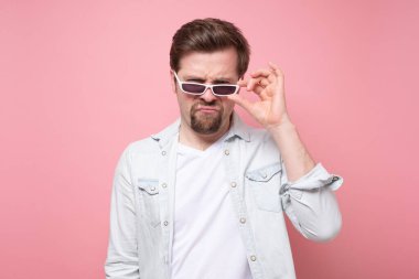 Komik yaz gözlüklü yakışıklı beyaz adam kameraya bakıyor.