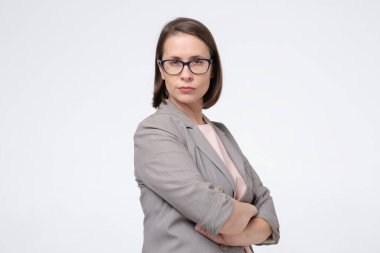 Çekici beyaz, gülümseyen kadın gözlükleri kameraya ciddi ciddi bakıyor.