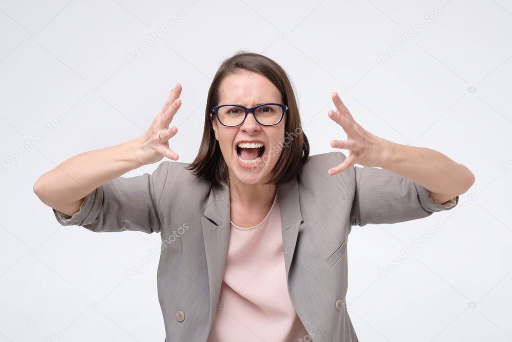 Screaming, hate, rage. Crying emotional angry woman screaming on white studio background.