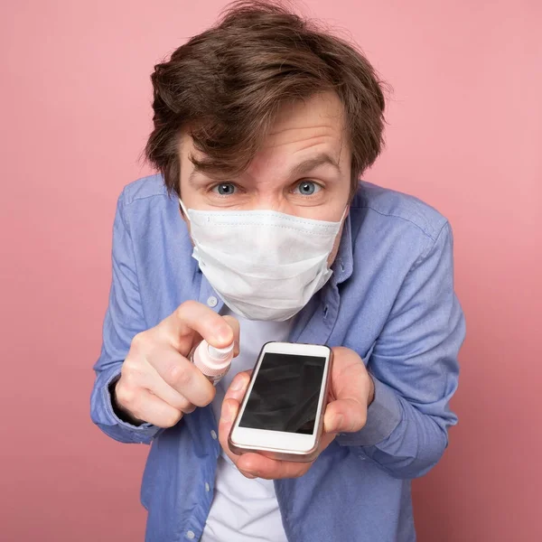 Hombre Caucásico Desinfectando Teléfono Inteligente Rociando Desinfectante Una Botella Precauciones —  Fotos de Stock