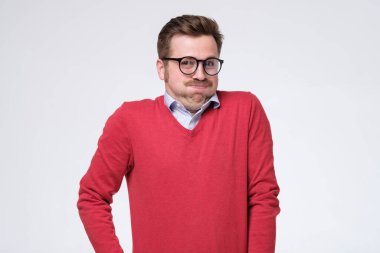 Gözlüklü yakışıklı bir genç ve soluk soluğa kalmış beyaz bir kazak. Stüdyo çekimi