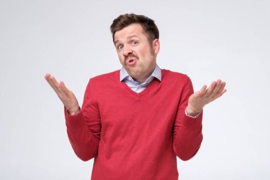 Kafası karışmış beyaz adam, beyaz arka planda ne yapacağına dair hiçbir fikri olmadığından emin değil..