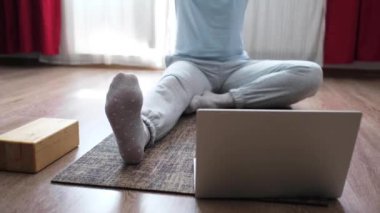 Kadın yoga yapıyor, paschimottanasana egzersizi yapıyor, öne eğilip poz veriyor.