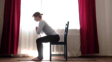 Sandalye yogası yapan kadın. Poz ya da utkatasana, evde bacak kasları için egzersiz..