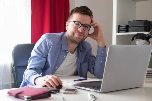 Кавказький зрілий чоловік у окулярах працює на ноутбуці вдома. — стокове фото