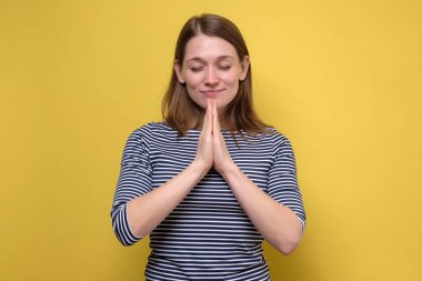 Sakin, rahatlamış güzel kız stres at, gözlerini kapat ve huzur içinde meditasyon yaparken gülümse.