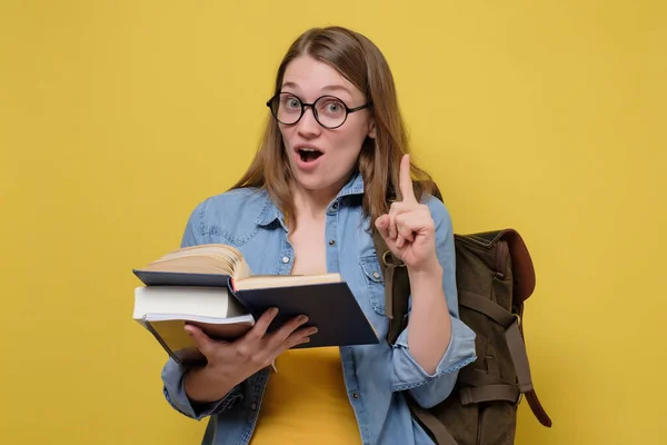 Estudante universitária jovem atraente carregando uma pilha de livros . — Fotografia de Stock