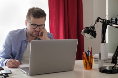 Kafkasyalı bir adam çalışma masasında oturmuş para sayıyor.