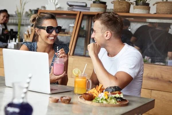 friends using laptop at cafeteria