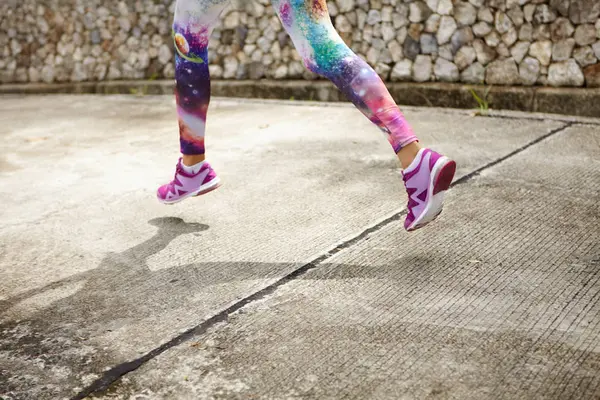 female runner in purple sneakers training outdoors