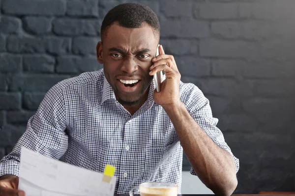 African-American businessman shouting at smartphone