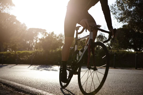 male wearing cycling clothing riding racing bike