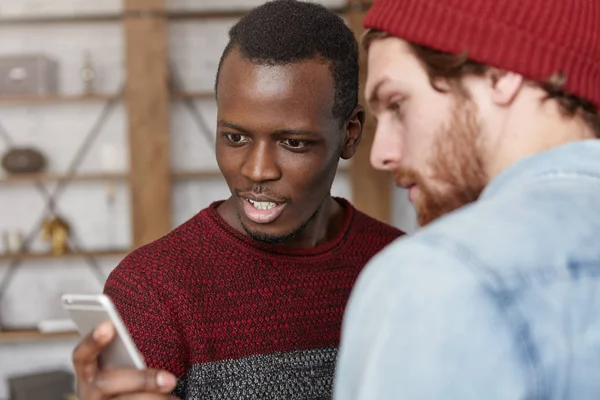 male using smartphone, showing his friend