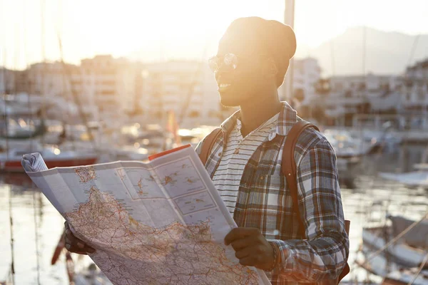 African male tourist holding map