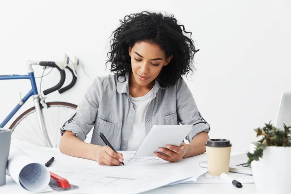 dark-skinned female architect making drawings