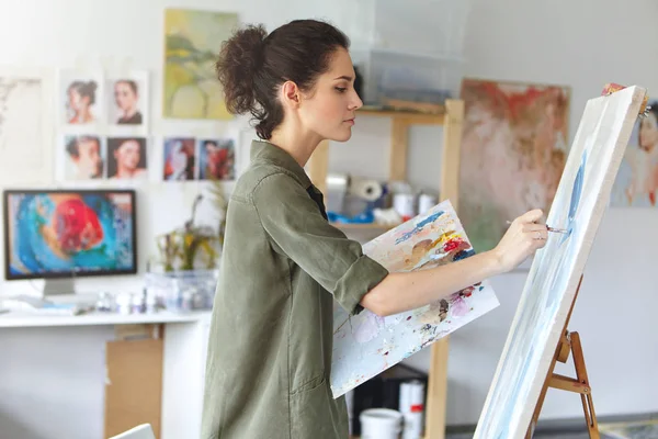 female painter painting on easel