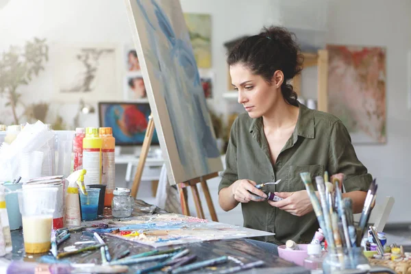 female painter sitting at table