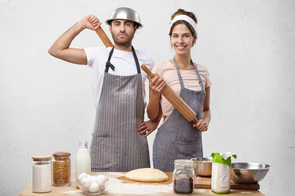 female wears apron, holds rolling pin