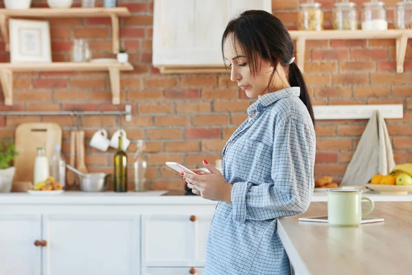 female looks seriously at smart phone