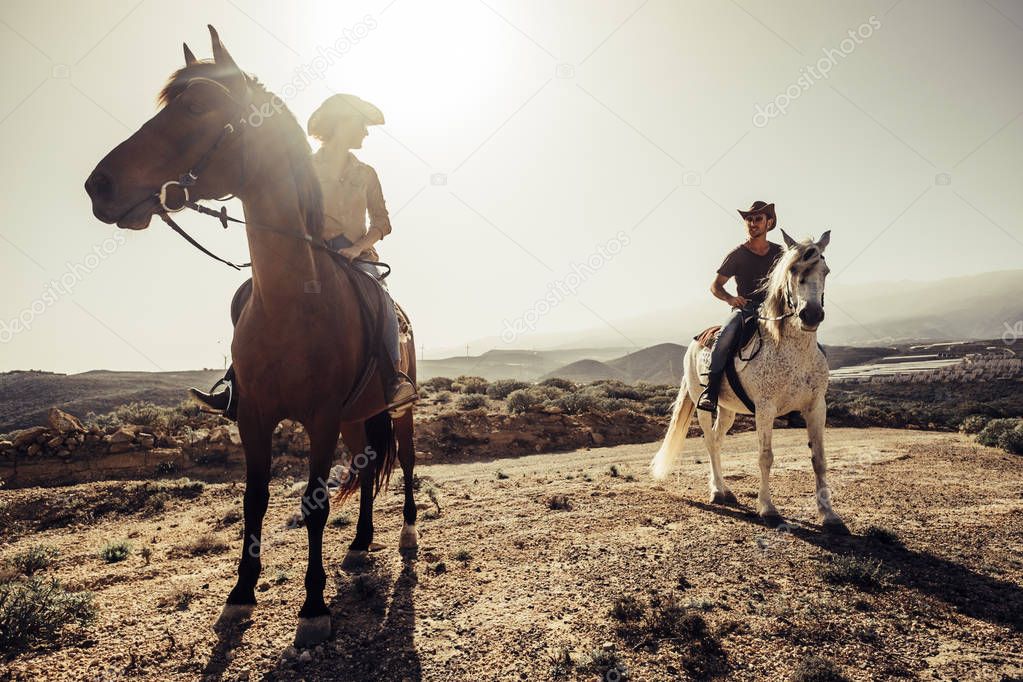 couple of riders and horses together on the road at the mountains. discover and travel the world in alternative lifestyle way. enjoy the nature and feel the silence. westerne concept scene