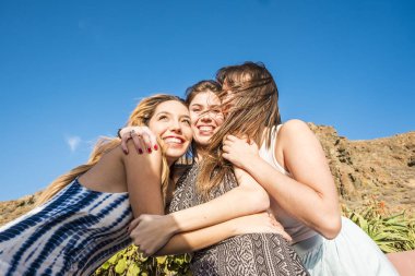 25 yıl yaşlı kız grup sarılmak ve birlikte gülmek bir dostluk takım çalışması. Güneşli gün tatil ya da bir grup için serbest zaman. Güzellik kadın.