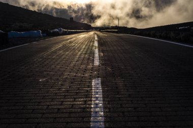 asphalt and white lines to go to hell, dramatic scene for fear and horror concept, clouds with sunlight behind and long direction. clipart