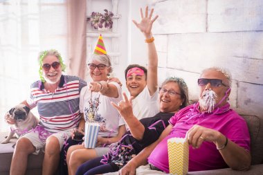 Grup yaşlı iki adam, iki kadın, bir çocuk ve bir küçük boksör birlikte vakit geçirmek. Oynama ve kılık ve renkli maskeleri evde ile gülüyor