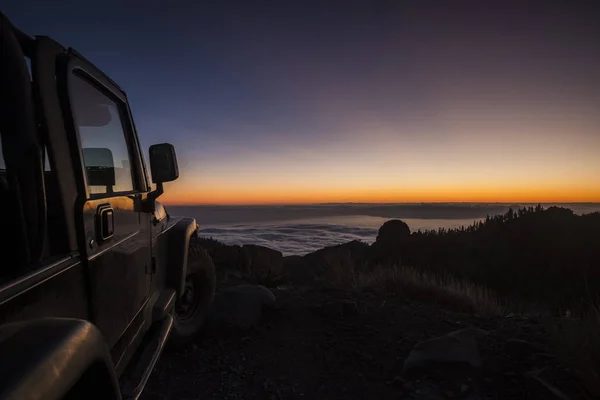 テネリフェ島エル テイデで夕景夕暮れの高いビュー ゴメラ方向の雲と温かみのある色調で 海を見てバルカン 美しい風景の静寂と沈黙のシーン 黒い車 — ストック写真