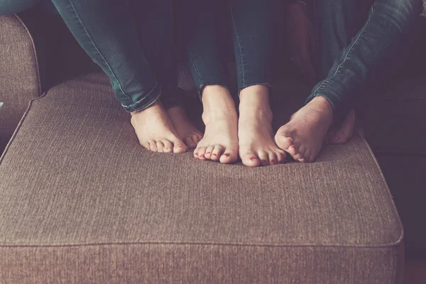 three woman nude feet at home on the sofa. sit down and stay close with friendship and relationship. lesbian concept for pure love and modernity.