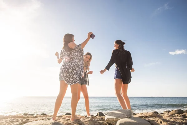 三位年轻美女在度假时在沙滩上跳舞的关系 在特内里费的日落时间 耀斑效应和温暖过滤器 — 图库照片