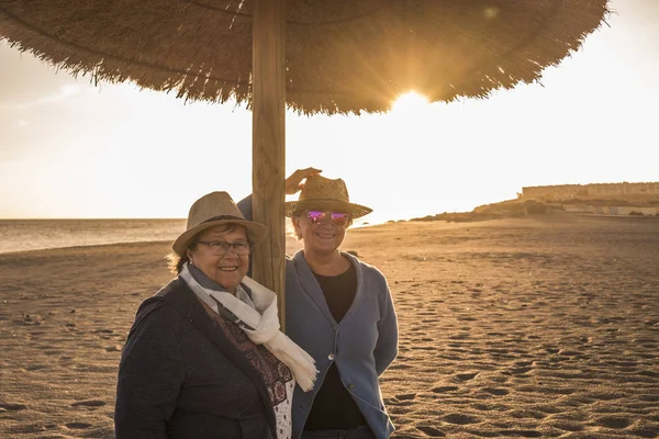 Two Senior Women Hats Beach Umbrella Sun Backlight Sunset Leisure — Stock Photo, Image