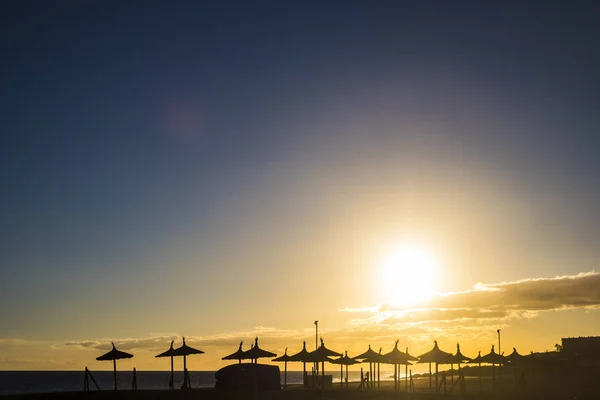 Siluet Turuncu Bir Günbatımında Ile Plaj Şemsiyeleri Ile Hiç Kimse — Stok fotoğraf