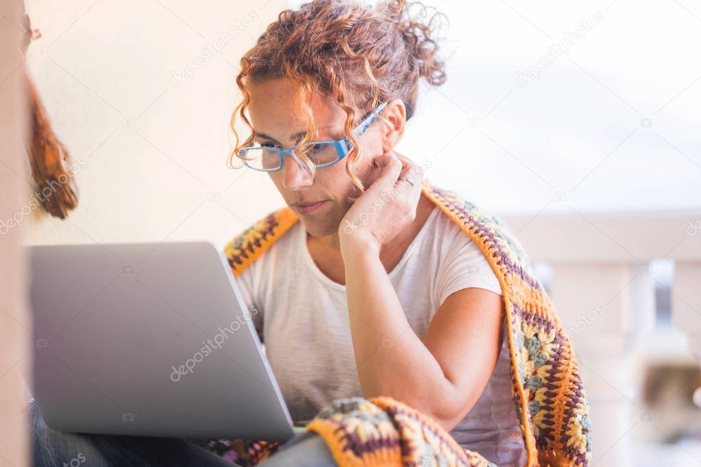 cute caucasian lady read on the laptop and work outdoor in the terrace. working at home freedom concept for independence strong and modern woman. alternative lifestyle concept.