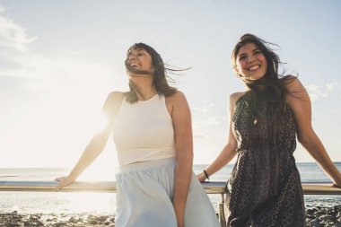 İki İspanyol Genç kız sarılmak ve kahkaha ile iyi bir hava katılmak ve rahatla. Tenerife beach mükemmel bir tatil için