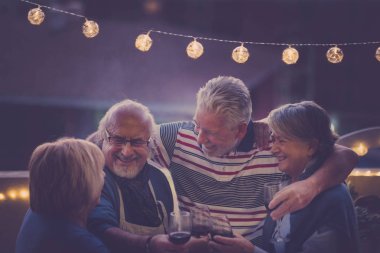 Adam odaklanmak. üst düzey Yetişkin Grup parti gece çatıda evde yapıyor yaşlı. Herkes birlikte sarılmak ve gülümseme ve güzel bir etkinlik için bir tatil sırasında açık gülmek. birlikte hafif ve içme şarap parti.
