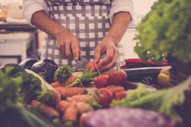 kadın evde mutfakta domates kesmek ve onun önünde bir tam sebze tablonuz. Sağlık ve kaygısız güzel yaşam tarzı ve vücut için. Fitness ve sağlıklı yaşam kavramı