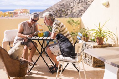 kıdemli yaşlı İçecek meyve suyu güzel okyanus manzaralı çatı katı terasında birkaç. Tatil ve emekli kavramı