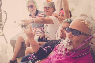 bir grup yaşlı adam beyaz saç, iki erkek, iki kadın, bir çocuk ve iki küçük pugs ile birlikte vakit geçirmek. Oynamak ve gülmek kılık ve renkli maskeleri evde