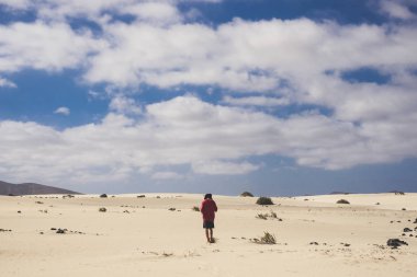 Yalnız çocuğun fuerteventura çöl. Yumuşak sarı kum ve dunes üzerinde yalınayak. Trekking ve alternatif seyahat ve yaşam kavramı.