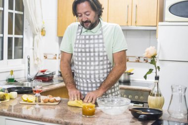 adam sakal ve önlük kadeh şarap ile ev onun mutfakta kek hamuru hazırlama.