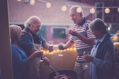 Barbekü barbekü ve bir olayı kutlamak için biraz şarap. bir grup yetişkin insan yaşam tarzı açık şehir manzaralı teras keyfini çıkarın. yemek yemek ve şarap içmek