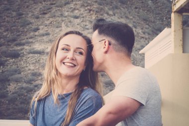 fısıltı ve gizli kavramı bir genç erkek ve kadın için açık terasta seviyorum. Vintage filtre için romantik bir sahne. sarışın güzel kadın gülümseyerek.