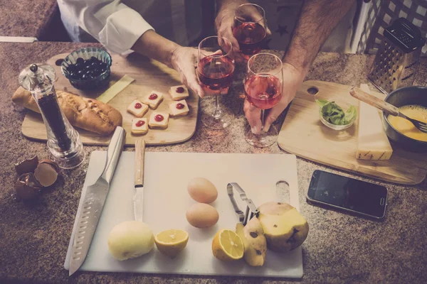 three people close up on hands on the table during a cooking time at home with family and friends. many raw food and mobile phone.