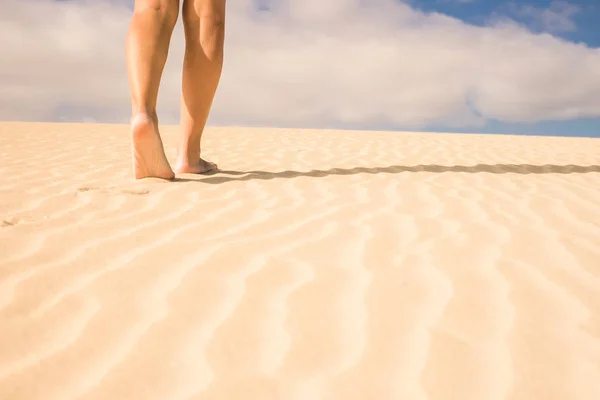 çıplak kadın bacakları Corralejo, Fuerteventura çöl dunes kum yürüme. Çıplaklık kavramı ve yaz saati. Mavi Gökyüzü bulutlu arka planda