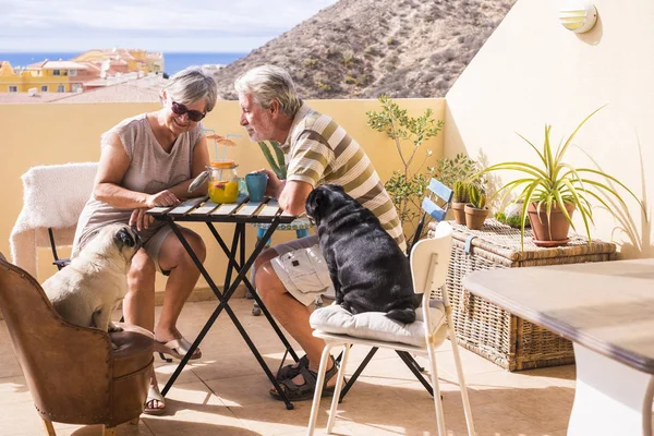 kıdemli yaşlı İçecek meyve suyu güzel okyanus manzaralı çatı katı terasında birkaç. Tatil ve emekli kavramı